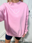 Up close photo of the smiley face embroidered on the front