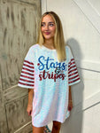 Up close photo of a woman modeling a white sequins t-shirt dress with red sequins stripes on sleeves and saying Stars & Stripes in blue and red sequins on the front. The back of dress is white cotton.
