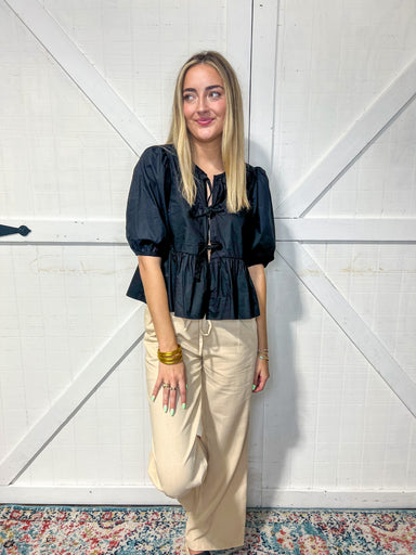 Woman modeling our linen dress pants that have a string tie at the waist.