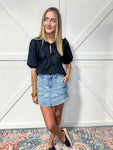 Woman modeling our medium wash denim cargo style mini skirt with pockets.