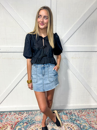 Woman modeling our medium wash denim cargo style mini skirt with pockets.