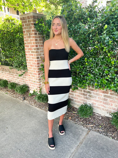A girl modeling our strapless black and white thick striped cotton midi dress that is straight and hugs your curves.