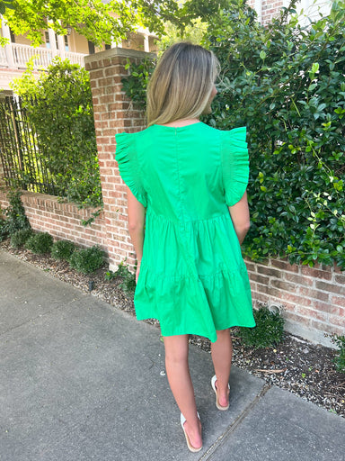 A woman modeling the back of our green margarita dress