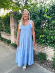 Woman modeling a chambray tiered midi dress with white ties for sleeves