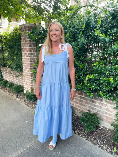 Woman modeling a chambray tiered midi dress with white ties for sleeves