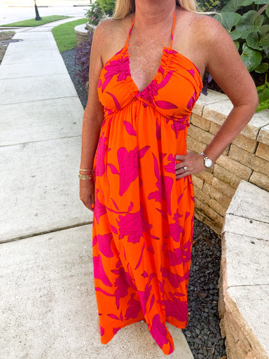 Up close photo of our orange maxi dress with magenta flowers all over