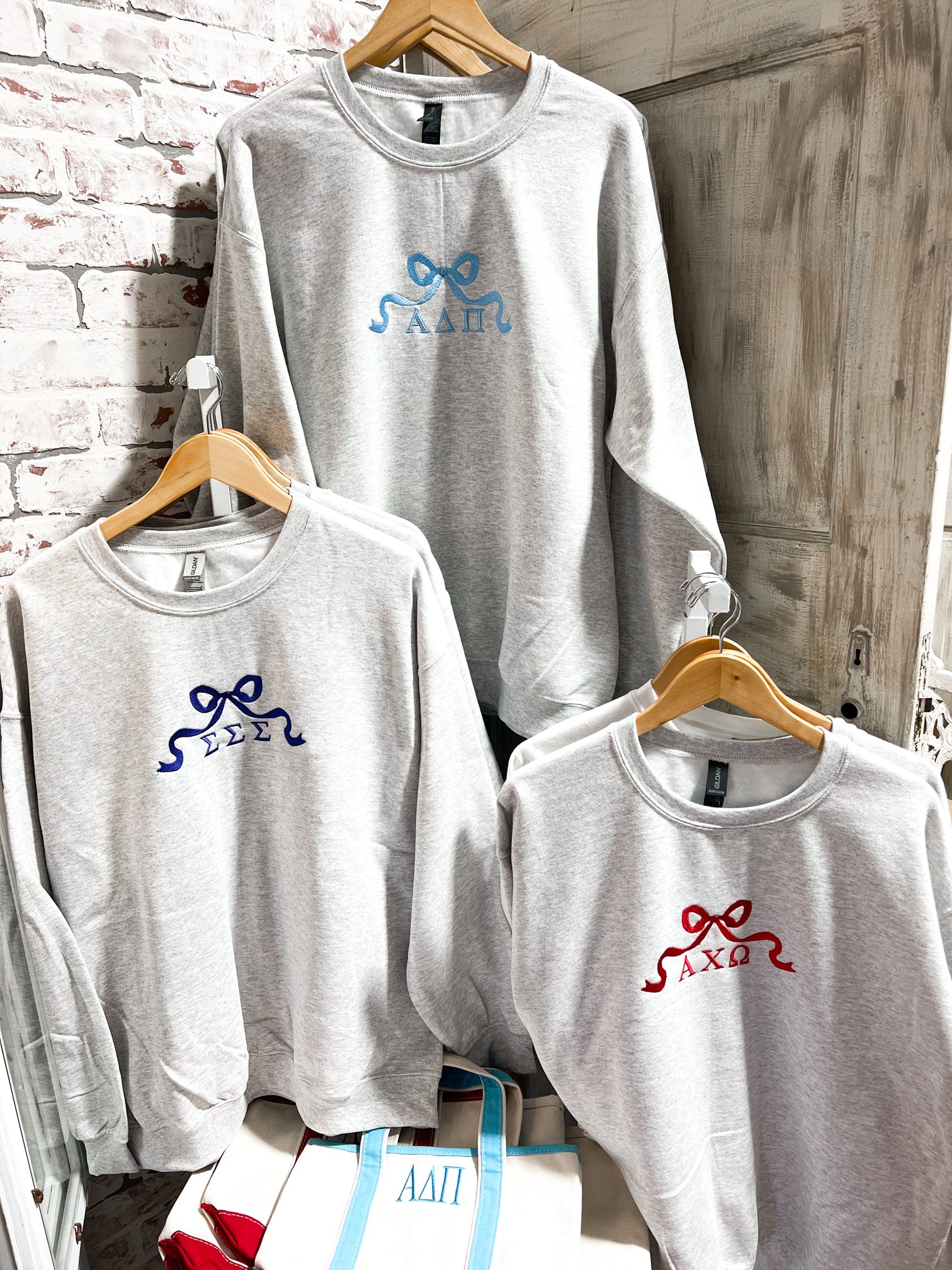 Photo showing three different sorority sweatshirts we have in Ash Grey