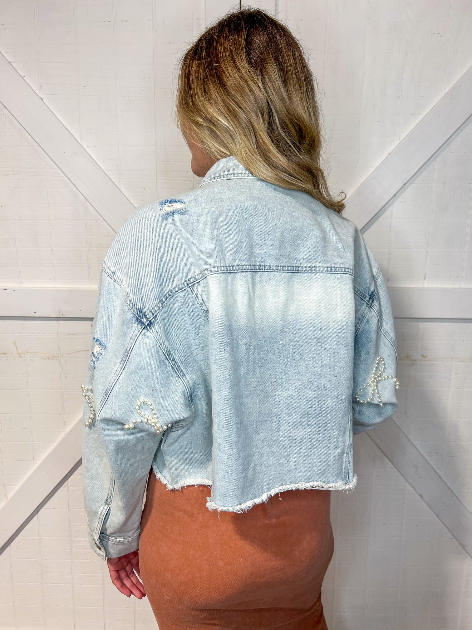 Woman modeling the back of our Bow Jean Jacket.