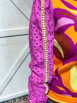 Up close photo of the orchid eyelet sleeves with yellow detail down the center of the long sleeve