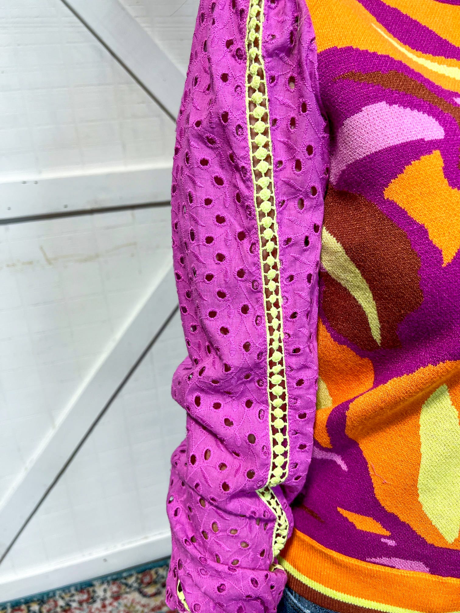 Up close photo of the orchid eyelet sleeves with yellow detail down the center of the long sleeve