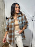 Young woman modeling a brown and light blue plaid button down shacket