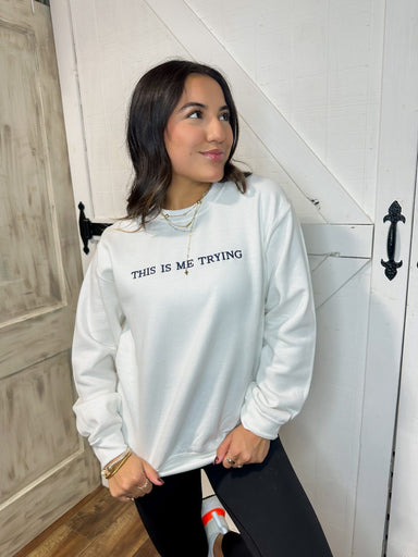 Woman modeling our white crew neck sweatshirt saying "This is Me Trying" embroidered in navy on the front across the chest area