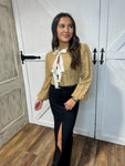 Young woman modeling our tan, long sleeve cardigan sweater with bow ties where buttons would be. 