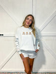 Young woman modeling our ash grey sweatshirt with three small teddy bears each holding a heart that says "love you"  embroidered on the front along with another teddy bear on the right sleeve and a heart on the left sleeve. It comes with matching grey shorts (not embroidered).