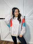 Young woman modeling our beige lightweight sweatshirt featuring a bold orange and turquoise stripe on the arms.