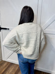 Photo of the back of our cream long sleeve sweater with wide sleeves