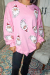 Up close photo of the sequin Santa heads on this light pink sweatshirt