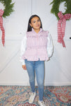 A woman modeling our lavender puffer vest with ruffles on the front and a big bow on the back