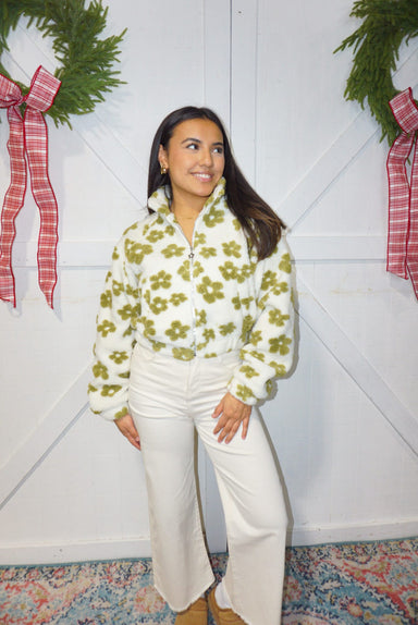 A woman modeling our fuzzy, white with green daisies zip-up jacket