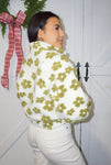 Photo of the back of our white with green daisies, fuzzy, zip-up jacket