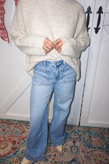 A model is showing our light denim, wide leg jeans with patch pockets on the front (normal pockets on the back also)