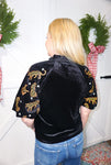 A photo of the back of this black velvet blouse showing the cheetahs and little stars on the sleeves