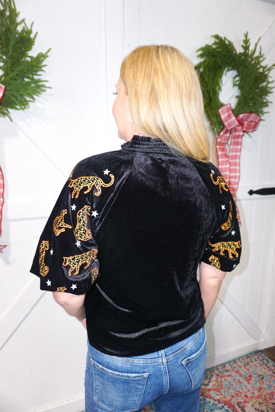 A photo of the back of this black velvet blouse showing the cheetahs and little stars on the sleeves