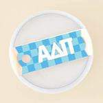 Photo showing the 40 oz tumbler lid up close. It has a blue checkered background and Alpha Delta Pi written in greek letters in white on top