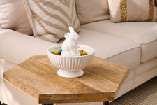 Photo showing our bunny light up ceramic sitter sitting in our candy bowl. Photo shows an example of what it would look like with the sitter in the bowl along with candy.