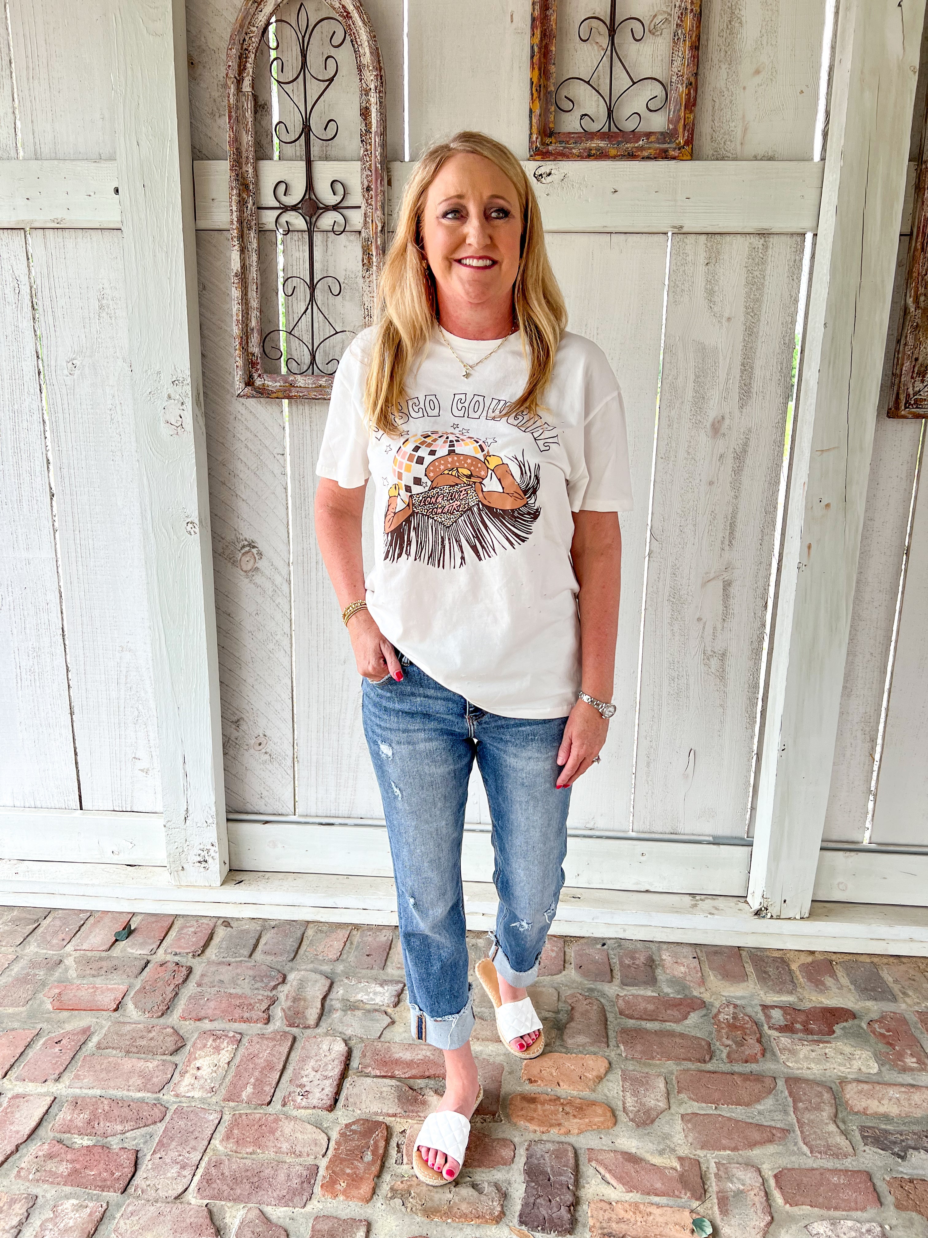 Full length photo of a woman modeling a medium wash cropped jeans with very light distressing and a cuff at the bottom for the crop