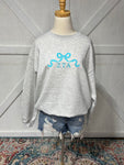 Up close photo of our ZTA bow design on an Ash Grey sweatshirt