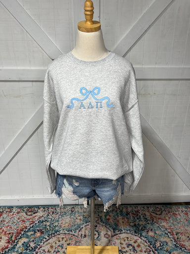 Up close photo of our ADPI bow design on an Ash Grey sweatshirt 