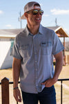 Photo of a man modeling our light washed denim pearl snap button up short sleeve shirt