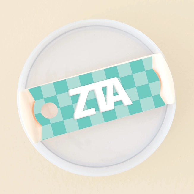 Photo showing the 40 oz tumbler lid up close. It has a turquoise checkered background and Zeta Tau Alpha written in greek letters in white on top